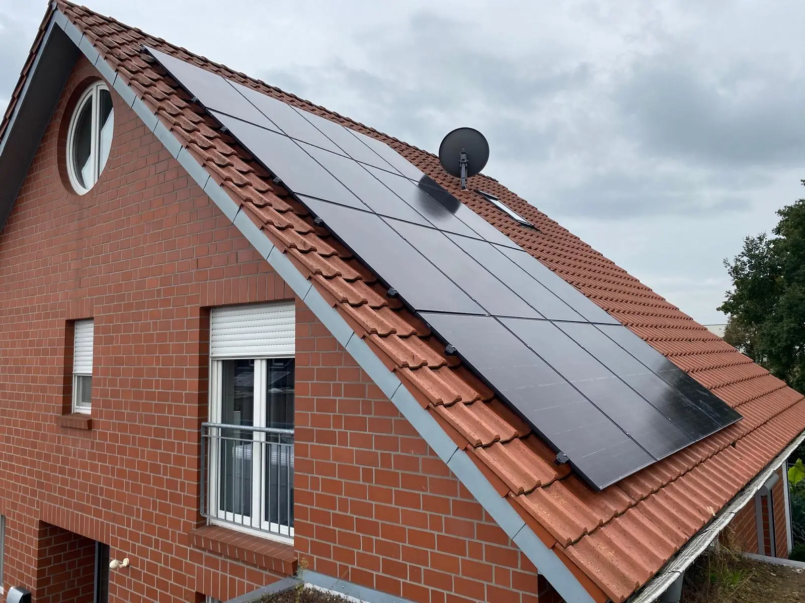 Schwarze Solarmodule auf einem roten Ziegeldach