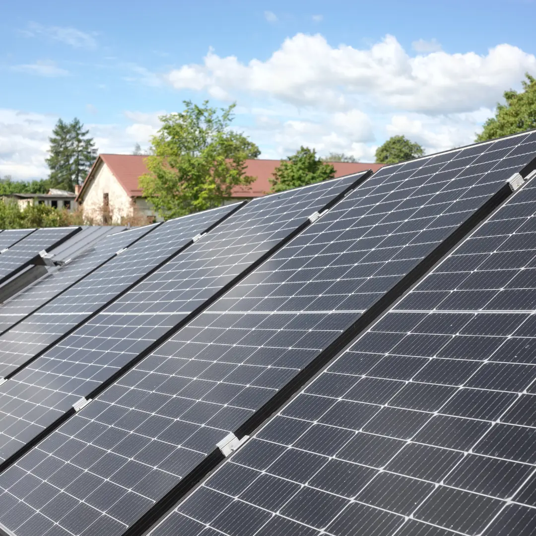 Solarmodule vor einem Bauernhaus mit rotem Dach